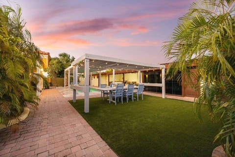 Outdoor dining space with pergola and garden setting for evening meals.