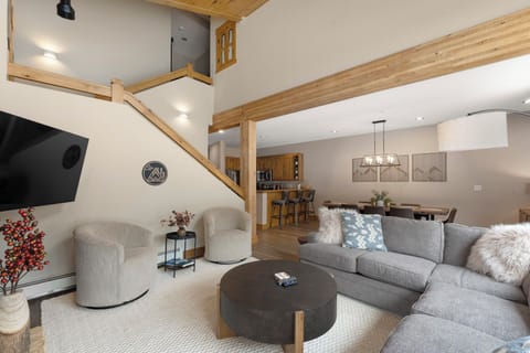 Living area with ample seating, queen sleeper sofa, gas fireplace, and mounted TV.
