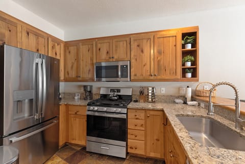 Full kitchen with granite countertops, stainless steel appliances, and breakfast bar seating 3.