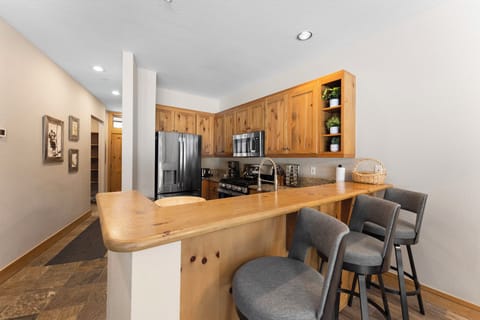 Full kitchen with granite countertops, stainless steel appliances, and breakfast bar seating 3.