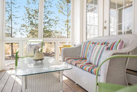 Beautiful screen porch spans the front of the home to relax in the breeze