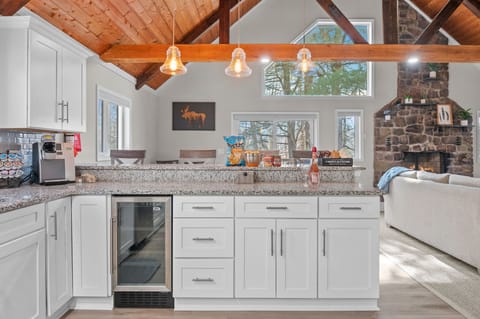 Bright and Functional
Sleek white cabinetry, exposed beams, and warm wood details bring together beauty and utility in this well-stocked kitchen.
