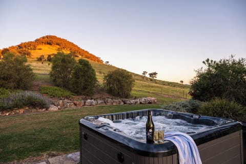 Unwind in the outdoor spa with a glass of wine as the sun sets over the rolling hills—an idyllic way to end your day in the countryside.