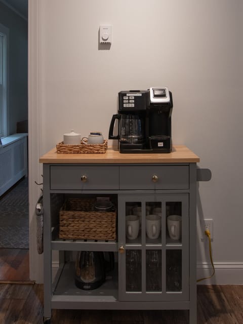 Coffee bar with coffee maker, coffee, tea, mugs, wine glasses