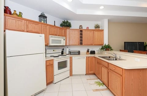 Spacious kitchen with full-size appliances, plenty of cabinet storage, tile flooring, and an open breakfast bar layout.