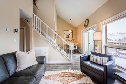 Open-concept living and dining area with fireplace, smart TV, and private deck