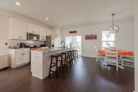 Modern kitchen with stainless steel appliances, granite countertops, and bar seating.
