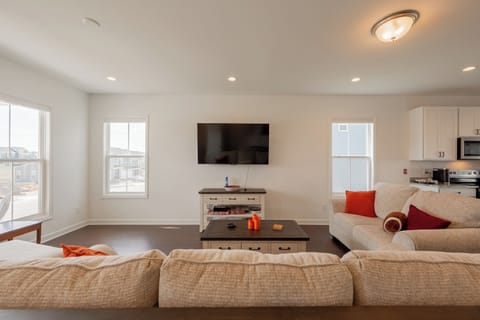 Cozy living room with smart TV, stylish decor, and room for the whole group.
