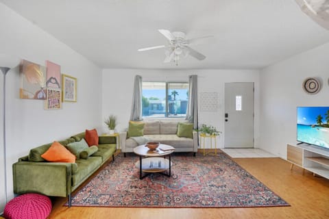 This living room combines modern style with cozy charm, featuring colorful accents, tasteful décor, and plenty of natural light to create a beautiful, welcoming and vibrant atmosphere.