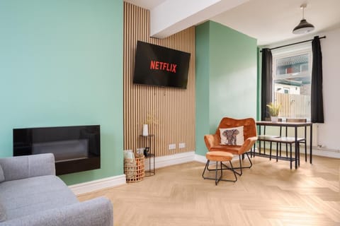 The comfortable living space includes a Smart TV with Netflix, a sofa bed for additional sleeping space, and a chair with an ottoman set—perfect for relaxing after a long day.