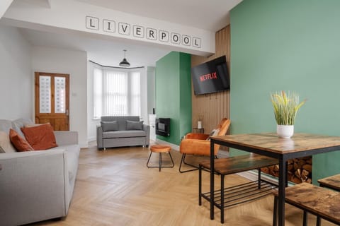 The comfortable living space includes a Smart TV with Netflix, a sofa bed for additional sleeping space, and a chair with an ottoman set—perfect for relaxing after a long day.
