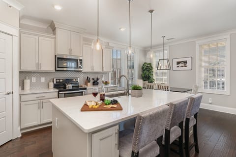 Unit 2: Fully equipped kitchen stocked with all culinary essentials, stainless steel appliances and an island offering bar seating for 3 guests.