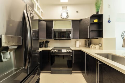 Full kitchen with black cabinetry, gas range, and modern appliances