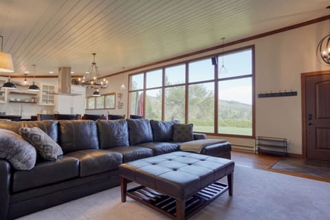 Relax in this living room w/ leather sectional and 85` TV.