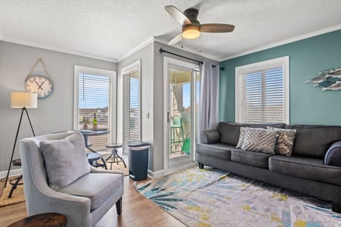 This oceanside living room provides a guest with a stylish beach escape experience.  The living room is equipped with a full sized couch which converts to a queen sofa sleeper, an additional readings chair, a Smart TV, and floor to ceiling  windows.
