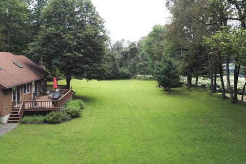 Deck overlooking the river with sprawling lawn.