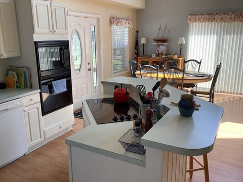 Kitchen area has extra bar seats and dining table has 6 for meals