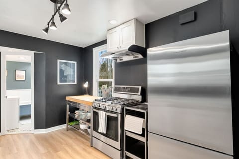 Fully stocked kitchen with modern appliances, open shelving, and everything you need for a home-cooked meal.