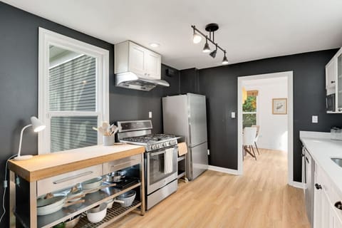 Fully stocked kitchen with modern appliances, open shelving, and everything you need for a home-cooked meal.