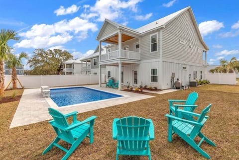 A private backyard pool with seating set beside the home.