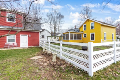 Charming yellow house with porch and landscaped front garden.








