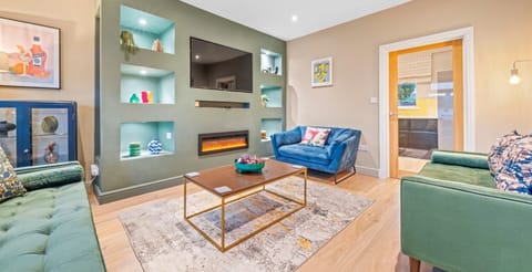 Unwind in style! This beautifully designed living room offers a warm and sophisticated atmosphere, complete with luxurious seating, an ambient fireplace, and a smart TV for your entertainment. The perfect place to relax after a day of exploring!