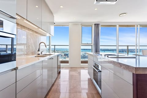 Sleek kitchen with harbour views – Floor-to-ceiling windows bring light and scenery right into your cooking space.
