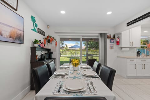 The beautiful dining table, accompanied by 6 elegant chairs, offers a serene view of the garden, making it the perfect spot to enjoy your meals in a peaceful and picturesque setting.