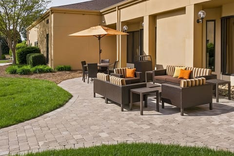 Lounge outdoors with cushioned seating and shady umbrella comfort.