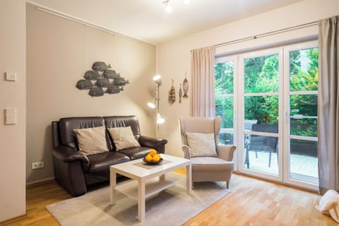 Living room with an armchair, a sofa, and a plate of fruit.