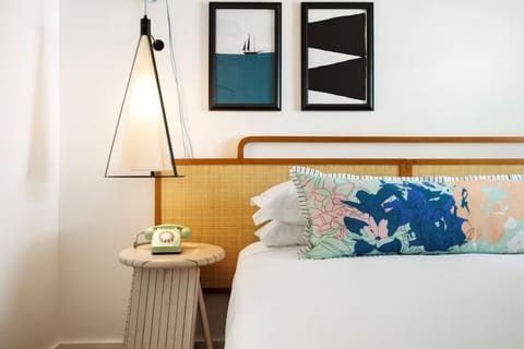 Drift off beside designer lighting and cheerful bedside details.
