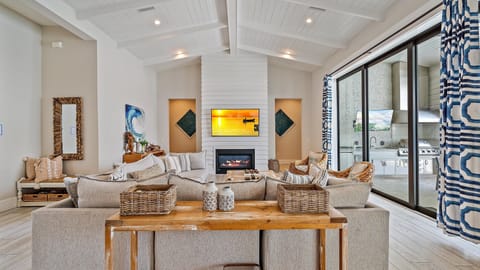 Great room overlooking the pool, the vaulted ceilings create a bright, coastal, airy ambiance throughout, while offering ample space for gatherings and reunions.