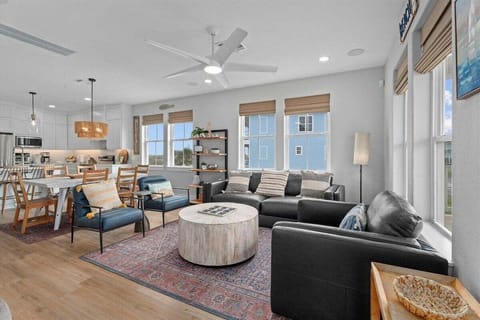 Open-concept living space with cozy seating, ceiling fan, and natural light—ideal for entertaining in a Galveston beach home.