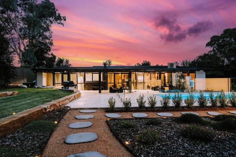 Follow the garden path to your private paradise, where curated landscapes and a poolside patio set the scene for stylish outdoor living and memorable group moments.