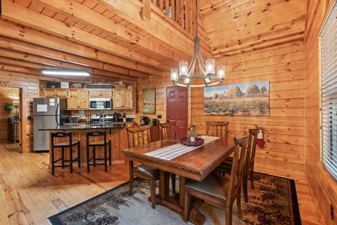 Gather around the large dining table, perfectly positioned near the front door and windows for warm natural light and cozy cabin ambiance.