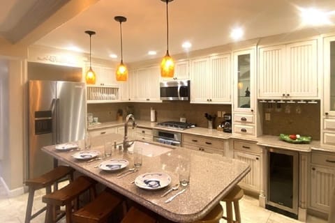 Bright coastal kitchen with island seating and warm lighting