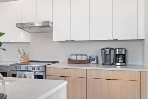 Fully equipped kitchen with white cabinetry and stainless steel appliances