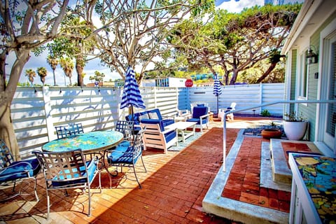 Unwind in your own private coastal courtyard, complete with cozy lounge seating, and lush shade from surrounding trees. This inviting outdoor space is perfect for morning coffee, afternoon cocktails, or evening conversations under the stars.