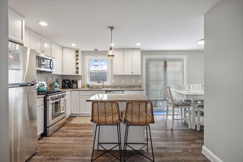 Fully equipped kitchen with updated appliances, coffee provided, and an island with seating for two.