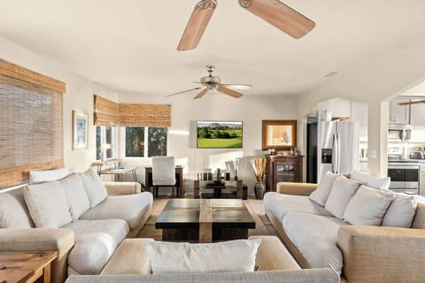 Spacious, open-concept living room with cozy designer sofas, modern decor, and natural light—perfect for relaxing or entertaining.