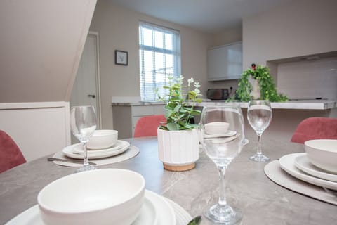 The dining table sits in a well-lit area of the home and provides a lovely place to enjoy meals with family or friends. Simple décor and functional seating make it practical and comfortable.