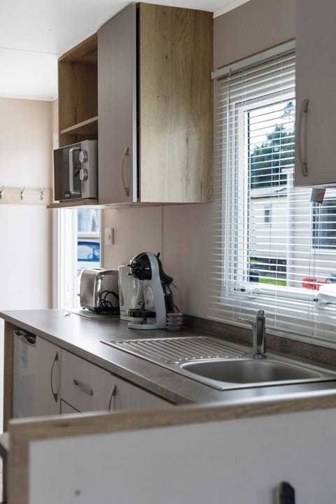 Modern kitchenette with essential appliances, including a coffee maker and microwave ideal for quick meals and refreshments.