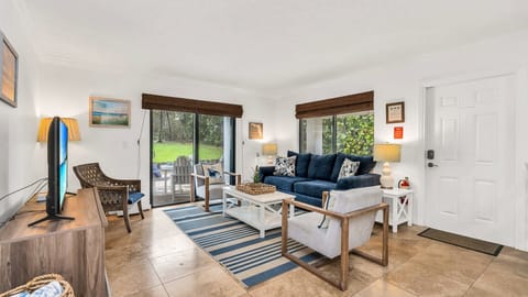 Bright, cozy, and coastal-chic. This inviting living room is the perfect place to unwind after a beach day—featuring comfy seating, tropical touches, and serene views just beyond the sliding doors