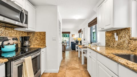Cozy meals made easy. This well-equipped kitchen opens to a charming dining nook set for four—perfect for breakfast before the beach or a laid-back dinner at home.