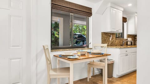 Cozy meals made easy. This well-equipped kitchen opens to a charming dining nook set for four—perfect for breakfast before the beach or a laid-back dinner at home.