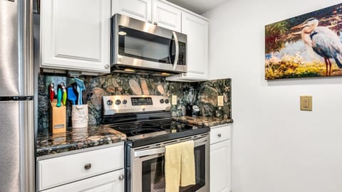 Fully equipped kitchen featuring stainless steel appliances, beautiful stone countertops, a drip coffee maker, toaster, blender, and everything you need to prepare meals at home.