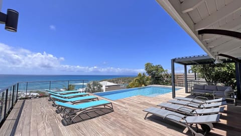 Infinity pool overlooking Anse à la Barque, on a vast wooden terrace facing the ocean.