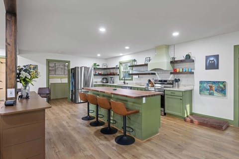 Fully stocked chef’s kitchen with stunning green cabinets.