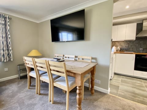 Dining table and tv in Morwennol holiday cottage in Harlyn Bay, Padstow, North Cornwall