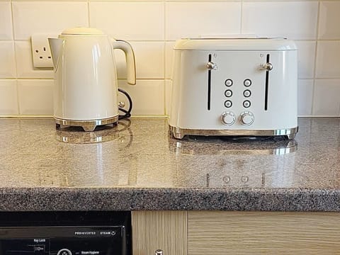 Cook with ease in this fully equipped kitchen, featuring modern appliances, ample counter space, and all essentials. Perfect for preparing delicious meals during your stay.